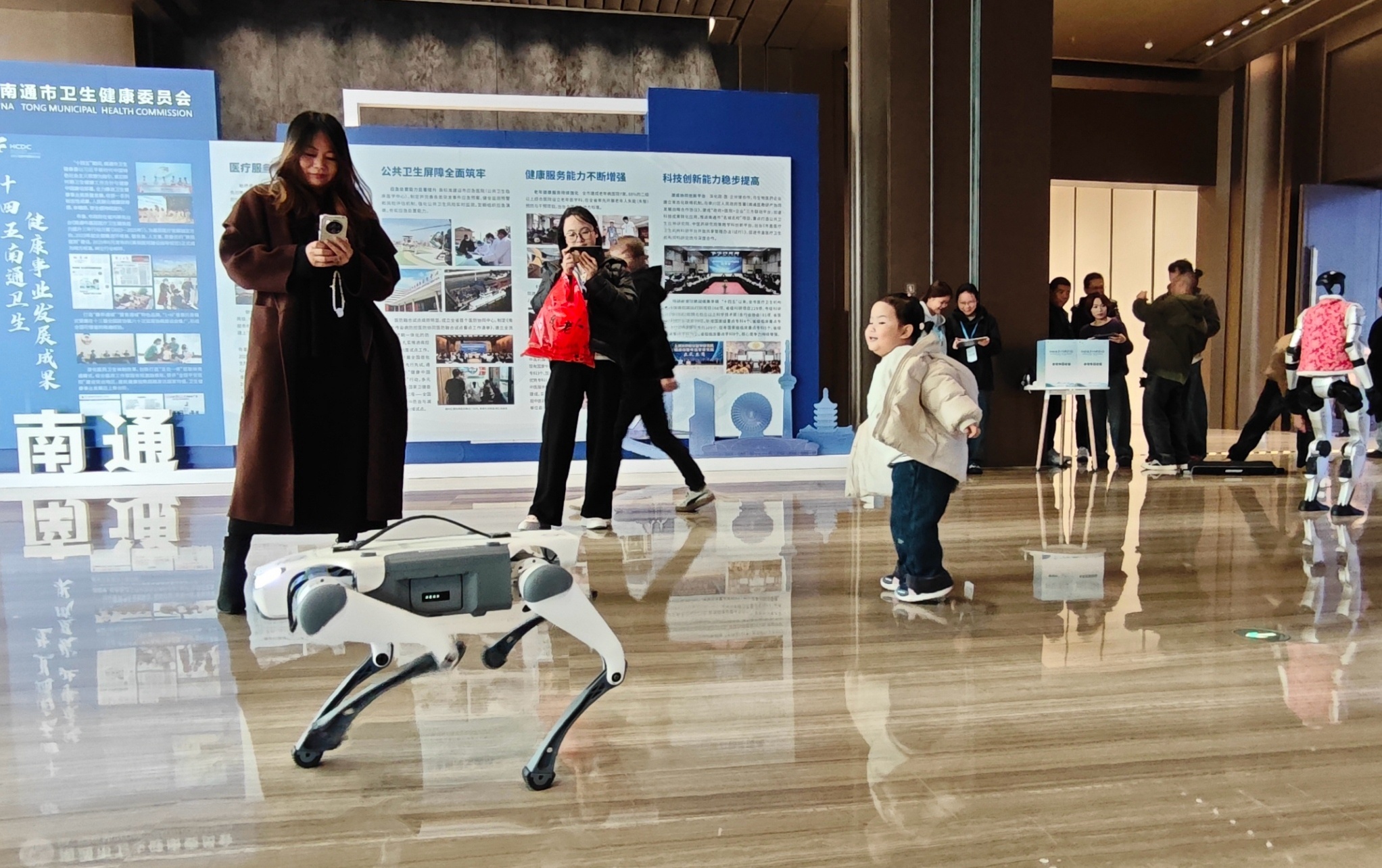 展区前的机器狗和机器人吸引了不少市民驻足。